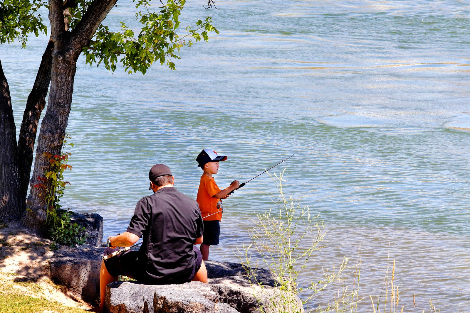 Kid fishing with his dad